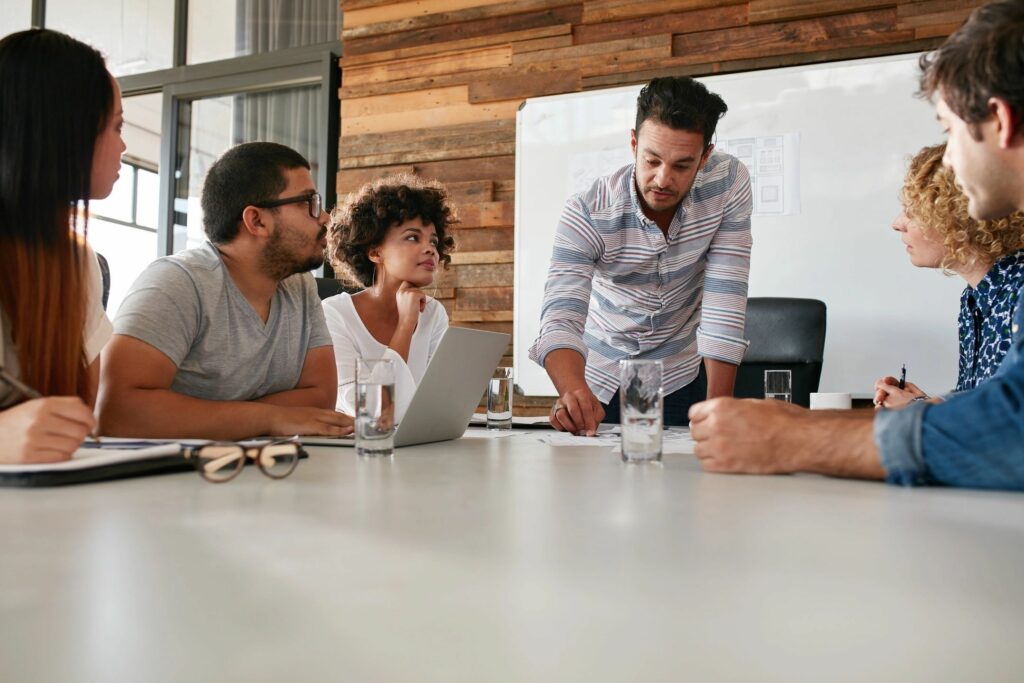 People sitting around a table in smart casual attire. This is an example of a meeting where a suit and tie would not make a good first impression.